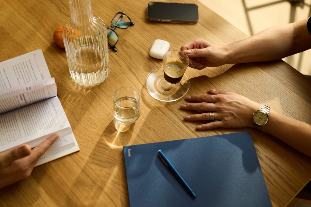 Table with bootle of water and people drinking